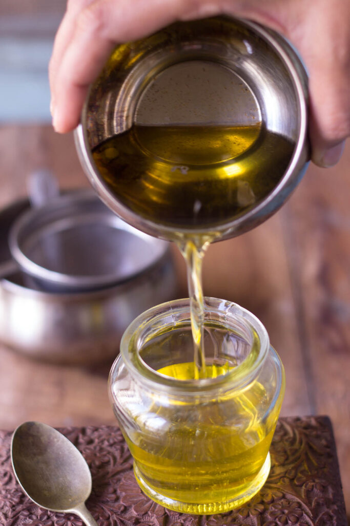 Freshly strained ghee, clear and golden, in a glass jar