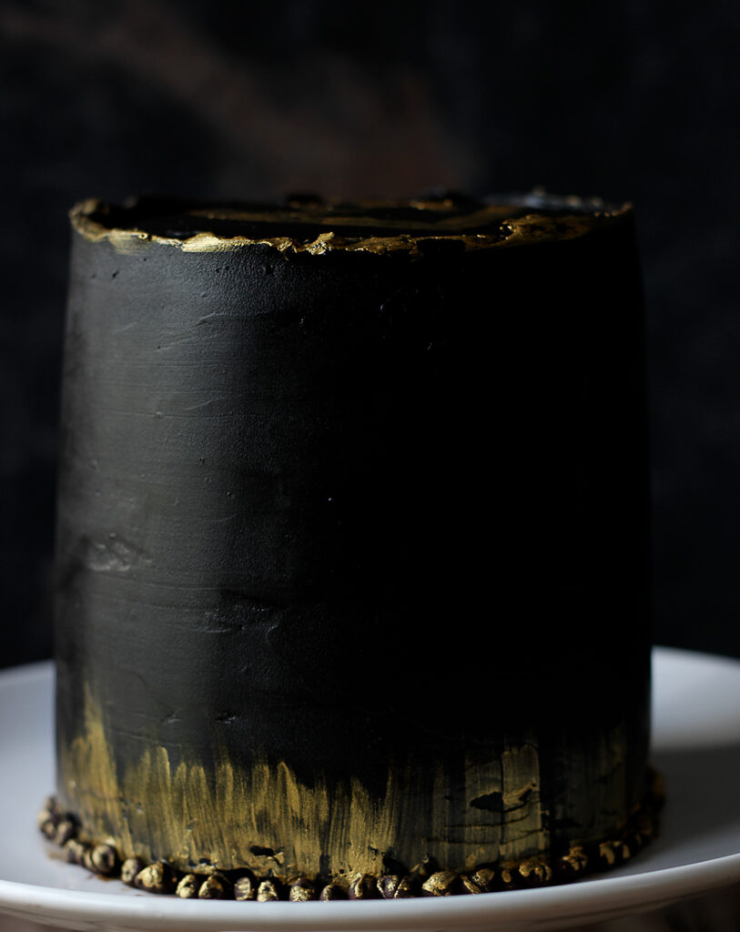 Close-up of the Black and Gold Chocolate Ganache Cake showing the smooth, glossy ganache and gold decorations