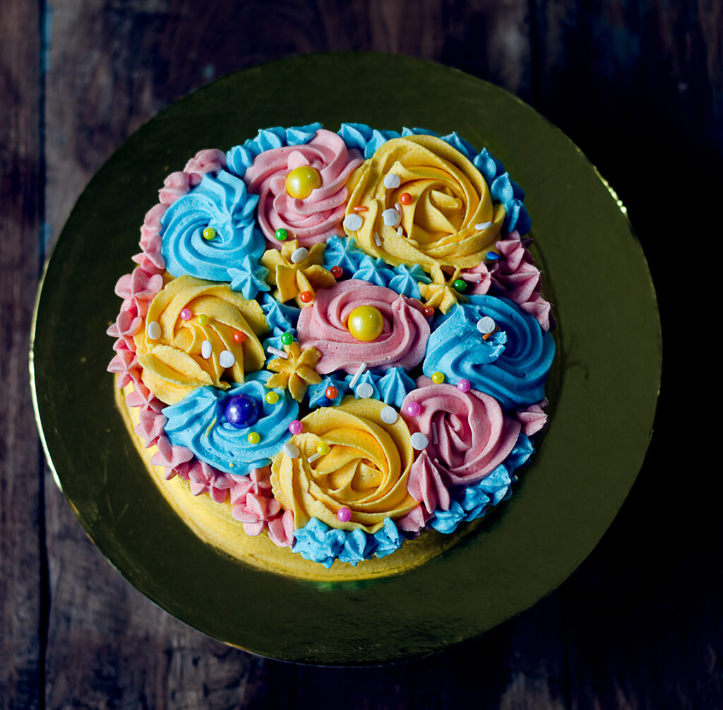 A top view of the fully decorated eggless buttercream garden cake, showcasing the detailed floral artwork