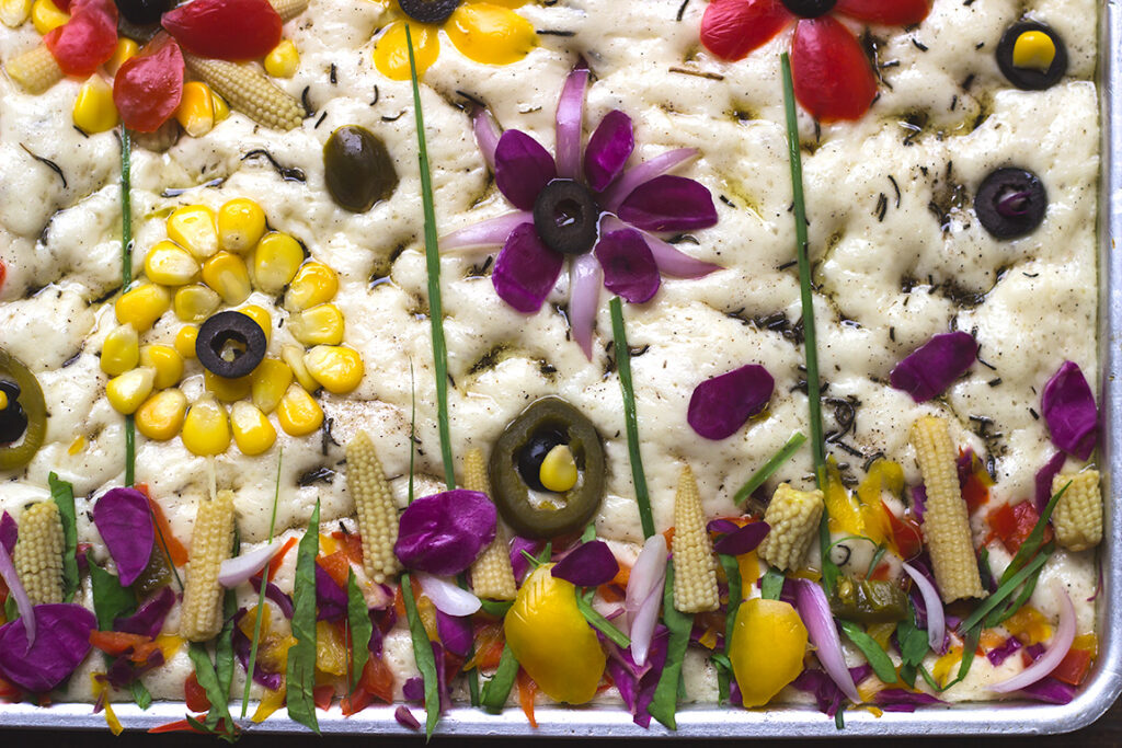 Overhead view of the garden focaccia, highlighting the intricate vegetable designs
