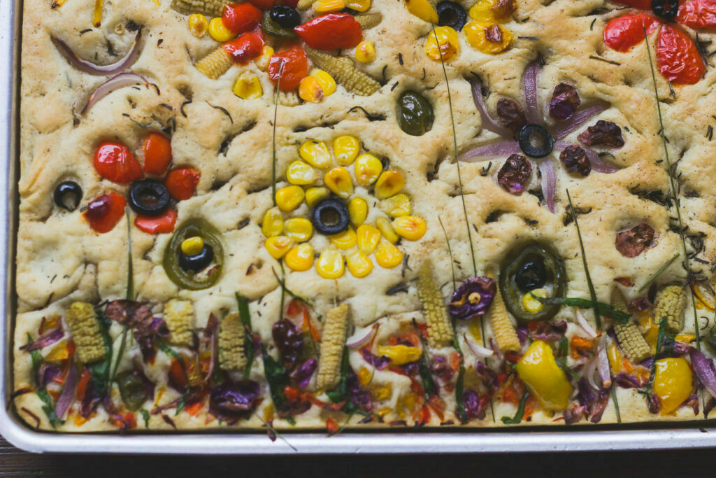 Freshly baked garden focaccia bread with vibrant vegetable decorations
