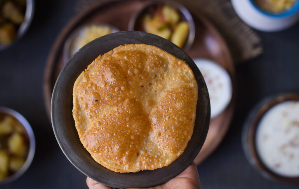 A freshly made Bedmi Puri puffing up as it fries in oil