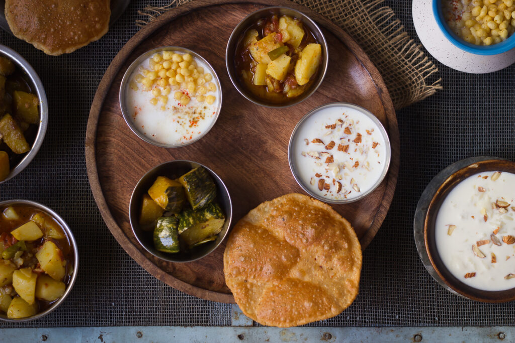 A beautifully arranged Satvik Thali featuring a variety of vegetarian dishes, served on a traditional wooden platter