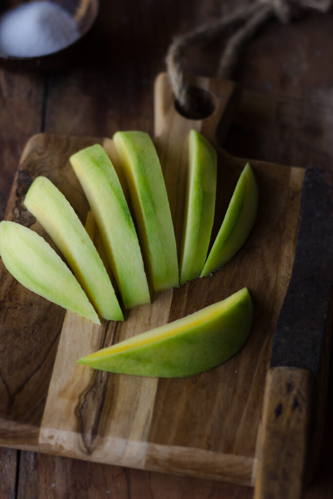 Raw mangoes sliced evenly to make pickle