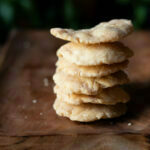 Close-up of a stack of golden-brown crispy Mathri with visible flaky layers