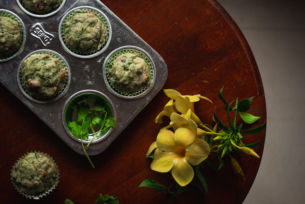 Healthy spinach cheese muffins on a plate with fresh spinach leaves