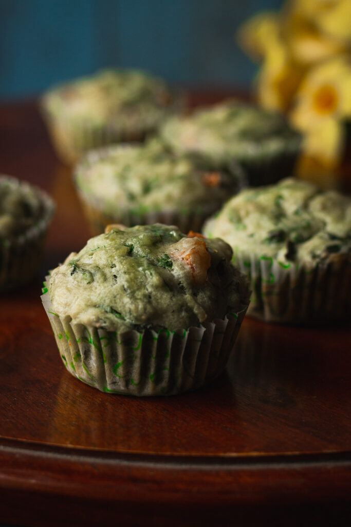 Golden-brown spinach cheese muffins cooling on a wire rack