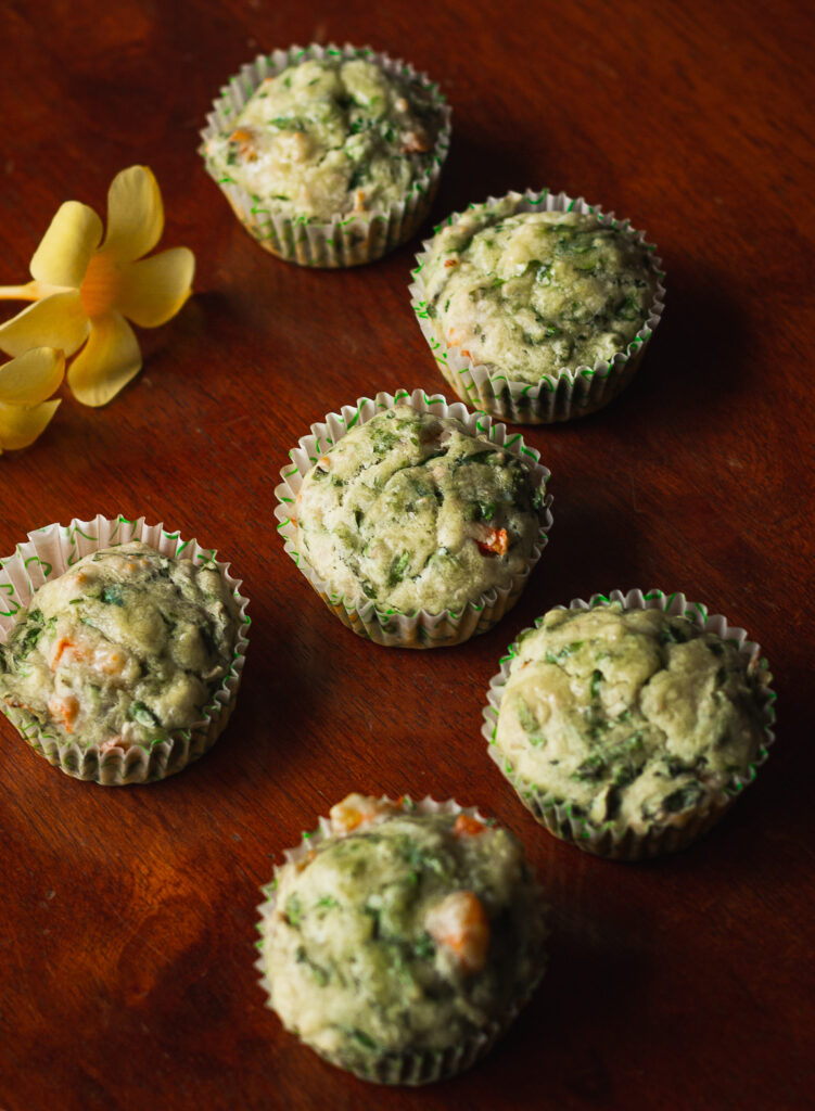 Freshly baked spinach cheese muffins with a golden crust, ready to eat