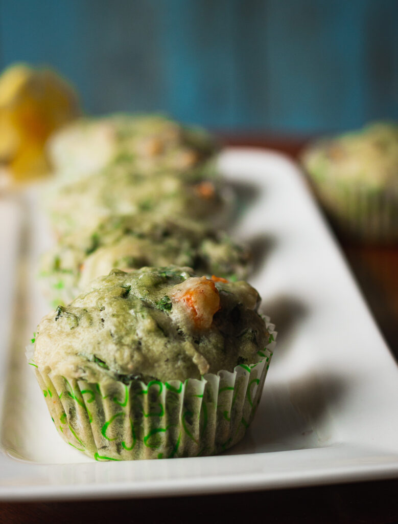 A basket of spinach and cheese muffins served with a side of butter