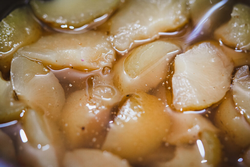 Freshly peeled amla segments mixed with sugar to prepare traditional amla candy.